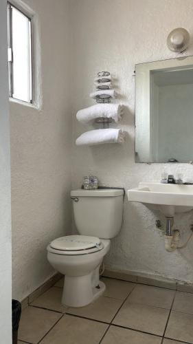 a bathroom with a toilet and a sink and a mirror at Economy Inn Motel in Kingman