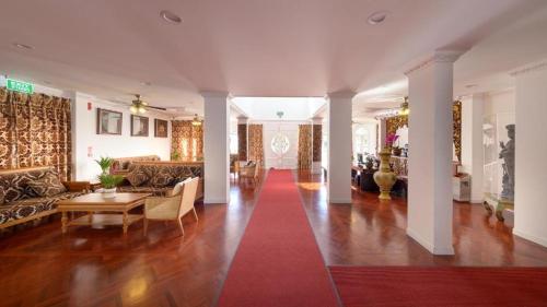 a living room with a red carpet and a couch at Lanna Inthan Hotel & Resort in Doi Saket