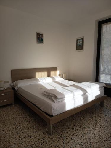 a bedroom with a large bed with white sheets at Albergo Bellavista in Re