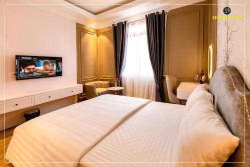 a hotel room with a bed and a television at Harmony Hotel Nam Định in Như Thức