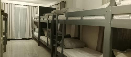 a room with several bunk beds in a room at Canaan Hôtel Antsirabe in Antsirabe