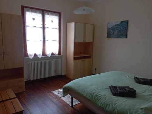 a bedroom with a green bed and a window at Casa Vacanze Sol&sport in Caprauna