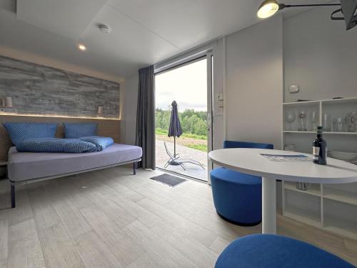 a living room with a couch and a table and a window at Feriendorf Seeblick - Tiny Nr 11 in Neunburg vorm Wald