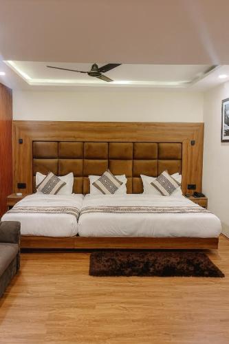 a bedroom with a large bed with a wooden headboard at The Heritage Chinar by Ackee Tree in Srinagar