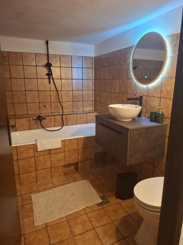 a bathroom with a tub and a sink and a toilet at Jinn's Valley Apartment in Grižane