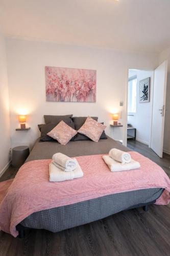 a bedroom with a large bed with two towels on it at L'Écrin Marguerite - Strasbourg-CMCO-Zénith-Espace Européen de l'Entreprise in Schiltigheim