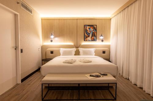 a bedroom with a large white bed in a room at Intercity Pamplona - The Universe Paulista in São Paulo