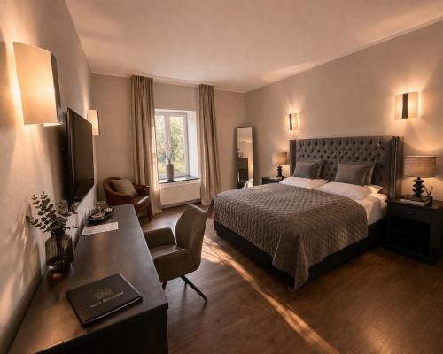 a hotel room with a bed and a desk at Gut Dyckhof in Meerbusch