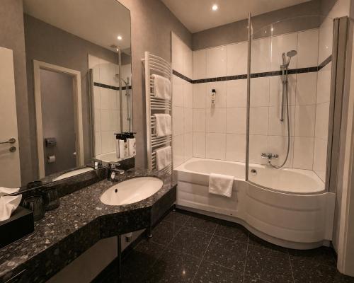 a bathroom with a sink and a tub and a shower at Gut Dyckhof in Meerbusch