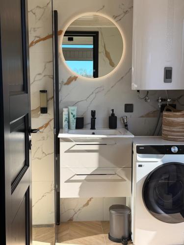 a kitchen with a sink and a washing machine at Sadama Willa Petite with private mini SPA in Heltermaa
