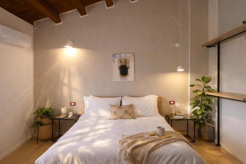 a bedroom with a large white bed with two tables at Noor Palace - PI Collection Hotel in Palermo