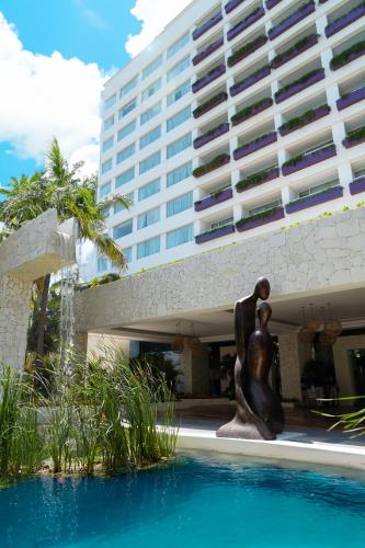 a statue of a woman next to a building at The Sens Cancun by Oasis - All Inclusive in Cancún