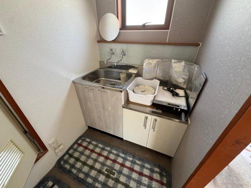 a small kitchen with a sink and a mirror at 久住みんなの森ロッジ202号-Kuju Forest Retreat 最大4名 in Kokonoe