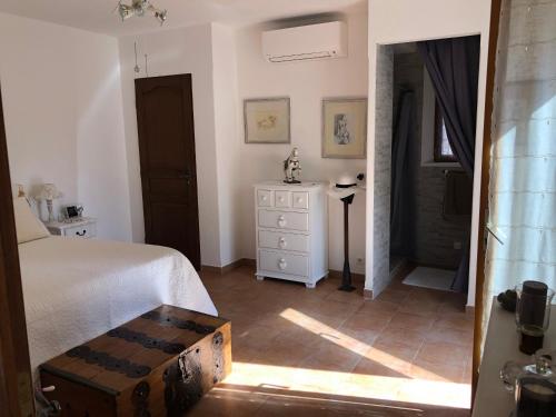 a bedroom with a bed and a dresser and a window at La calade in Roquefort-les-Pins