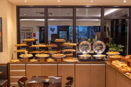 a buffet line with many different types of pies at Intercity Pamplona - The Universe Paulista in São Paulo