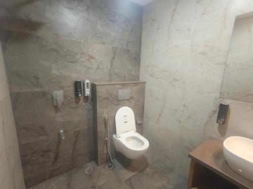 a bathroom with a toilet and a sink at Hotel Vardaan Inn in Lucknow