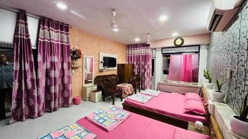 a bedroom with a pink bed and a living room at Marble Man Homestay in Agra