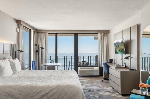a hotel room with a bed and a balcony at Nautilus Inn - Daytona Beach in Daytona Beach