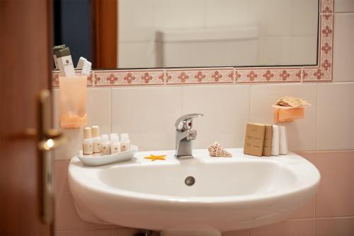 a sink in a bathroom with a mirror at Relais Casina Copini in Spongano