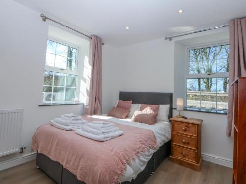 a bedroom with a bed with towels on it at Gate House in Llangefni