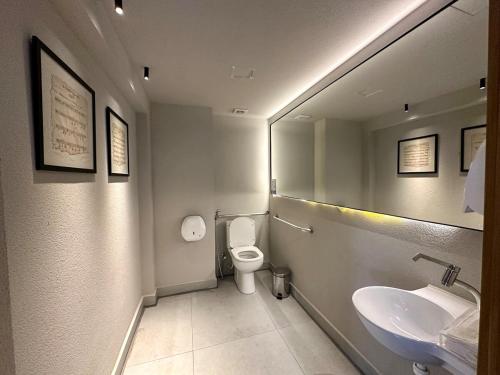 a bathroom with a toilet and a sink and a mirror at Restinga 305- Flat vista mar no Bessa - ASKA in João Pessoa