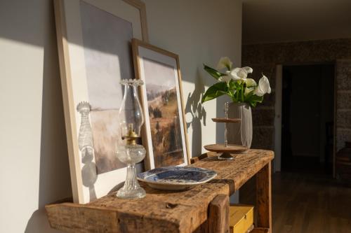 ein Zimmer mit einem Tisch, auf dem eine Vase mit Blumen steht in der Unterkunft Casa d`Acucanha in Penafiel