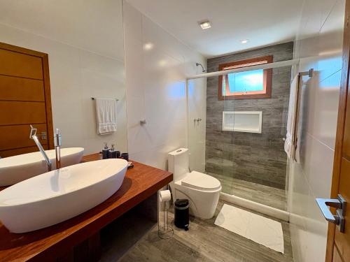 a bathroom with a sink and a toilet and a shower at Chalet Monte Boa Vista - Aconchego na Serra com Hidromassagem Exclusiva in Teresópolis