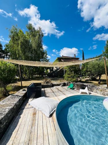 a swimming pool sitting on a wooden deck next to a patio at Maison Quercus in Vaylats