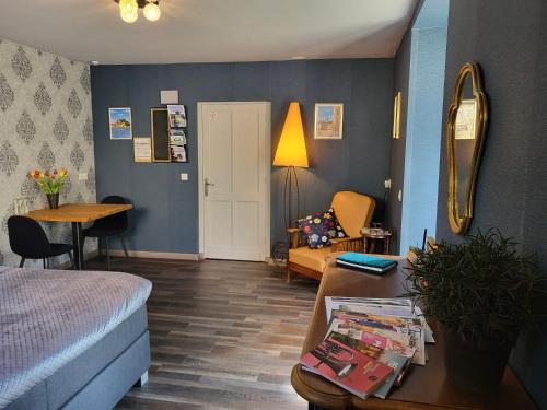 a bedroom with a bed and a table and a couch at Chambre d'hôtes l'Heure Bleue in Saint-Alvère