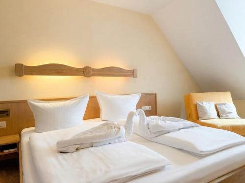 two beds with white towels on them in a room at Hotel Restaurant Bären in Weingarten