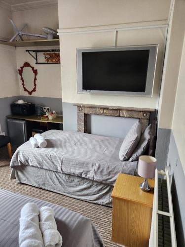 a bedroom with a bed and a flat screen tv at Spalite Hotel in Gloucester