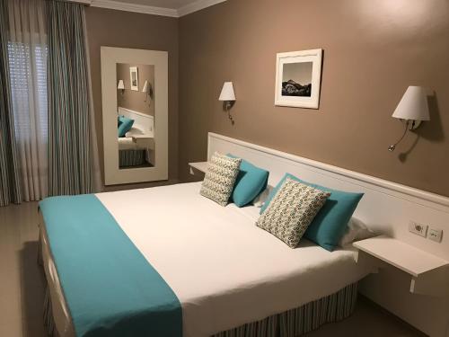 a bedroom with a large bed with blue pillows at MC La Quinta in Santa Úrsula