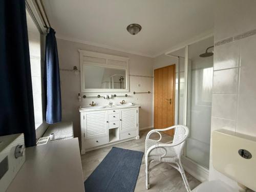 a bathroom with a white sink and a mirror at Ferienhaus Villa Deichfürst in Dorum-Neufeld