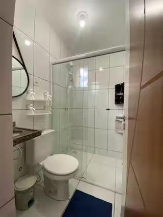 a bathroom with a toilet and a glass shower at Ed The Rock in Belém