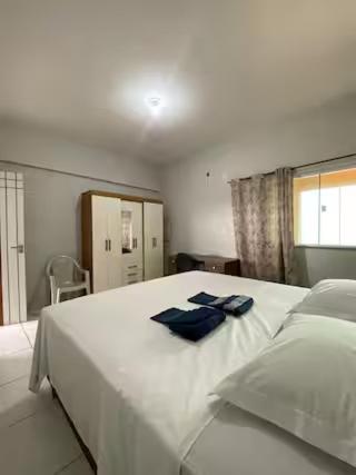 a bedroom with a large white bed with blue towels on it at Ed The Rock in Belém