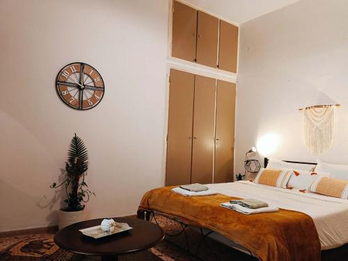 a bedroom with a bed and a clock on the wall at Mia Nest in Artemida