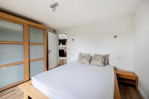 a bedroom with a white bed and a window at Large bright apartment in Lessines