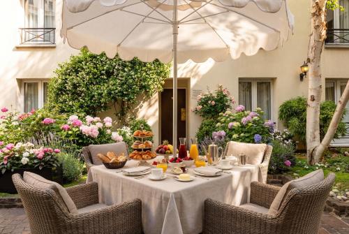 a table with food on it under an umbrella at Le Patio Bastille in Paris