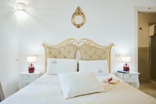 a bedroom with a large white bed with two lamps at B&B Magnolia Centro Storico Grottaglie in Grottaglie