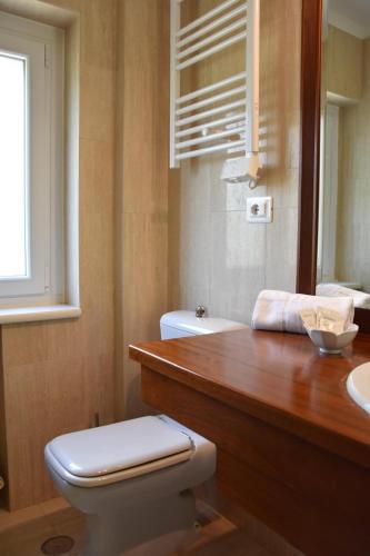 a bathroom with a toilet and a sink and a mirror at Thalore room e apartments in Amantea