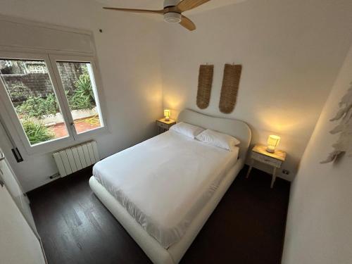 a bedroom with a white bed and two windows at Stylish Home with Terrace and Private Pool, Maresme in Cabrils