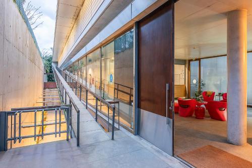 an external view of a building with stairs and red chairs at HI Ponte de Lima - Pousada de Juventude in Ponte de Lima