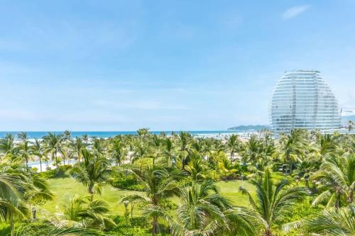 a view of a beach with palm trees and a building at 4-BR paradise view in Acapulco in Acapulco