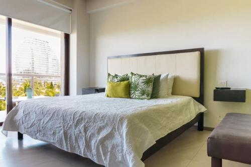 a bedroom with a large bed with yellow pillows at 4-BR paradise view in Acapulco in Acapulco