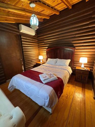 a bedroom with a large bed with two lamps at Hotel La Leyenda Sonora in El Saucito