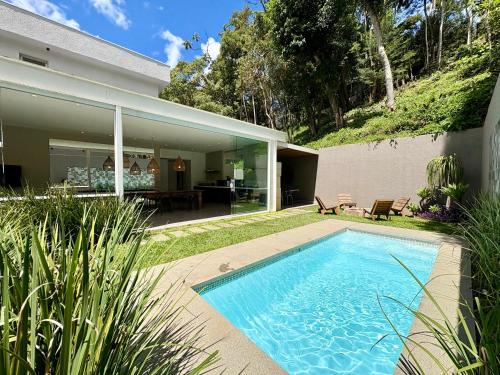 a swimming pool in front of a house at Casa 10 Floresta Boa Vista - Piscina Privativa, Adega e Conforto em 4 suítes in Teresópolis