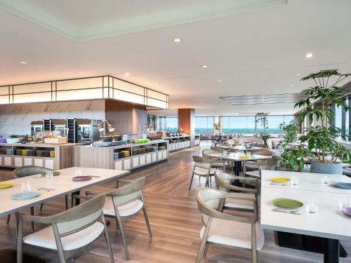 a restaurant with tables and chairs and a kitchen at Grand Mercure Nasu Highlands Resort & Spa in Nasu