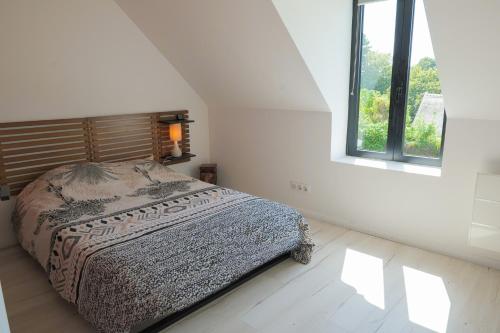 a white bedroom with a bed and a window at "La Villa Gozforn" avec piscine privée, plages et commerces de la station balnéaire de Beg-Meil à pied! in Fouesnant