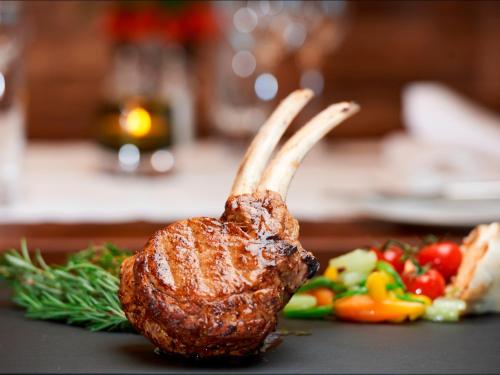 a piece of meat with horns on a table with vegetables at Panorama Resort & Spa in Feusisberg