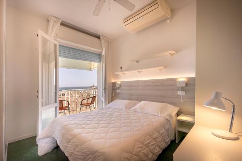 a bedroom with a bed and a view of the ocean at Hotel Sanremo in Caorle
